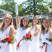 Students with white dresses and flowers